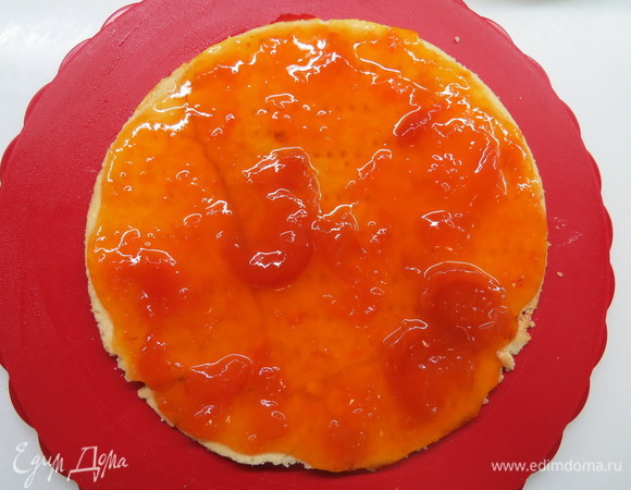 На данном этапе можно осуществить первичную сборку основы нашего торта. Песочный корж поместить на блюдо или подложку. Равномерно распределить абрикосовый джем по поверхности коржа.