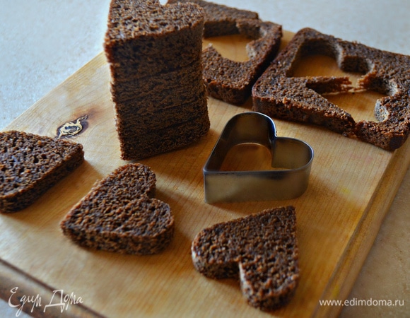 Из бородинского хлеба (1 маленькая буханка, 9 кусков, 18 сердечек) с помощью формочки для печенья вырежьте сердечки.
