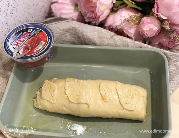 Верх рулета украсьте листочками, вырезанными из остатков теста. Смажьте рулет взбитым яйцом.