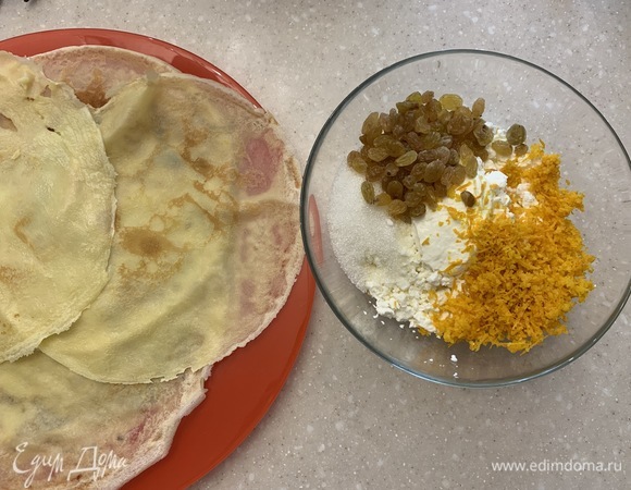 Творог взбиваем блендером со сметаной и оставшимся сахаром, добавляем цедру, изюм и еще раз все хорошо перемешиваем. На край блинчика выкладываем начинку и сворачиваем трубочкой. Возвращаем блины на сковороду и слегка поджариваем. Перед подачей посыпаем сахарной пудрой и украшаем листьями мяты. Блинчики получаются очень нежные и безумно вкусные! Всем приятного аппетита. С наступившей Масленицей!