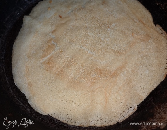 Затем перевернуть блинчик на другую сторону и жарить еще примерно полминуты. Таким способом испечь все остальные блинчики.