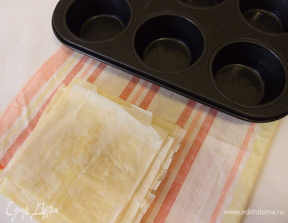 Тесто фило предварительно разморозить и аккуратно нарезать на квадраты со стороной 10 см. Квадраты смазать сливочным маслом и положить друг на друга в 5 слоев.