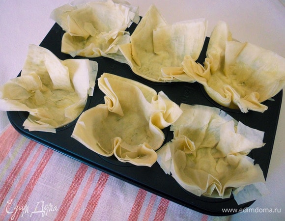 Вложить тесто в форму для выпечки маффинов так, чтобы края теста остались снаружи. Расправить их в виде цветка.