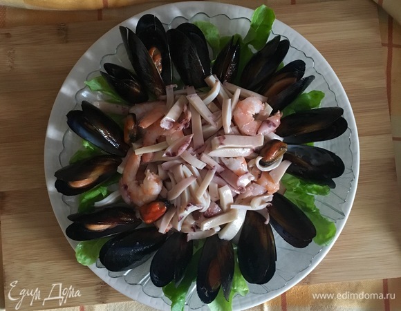 В середину салатницы выложить креветки с кальмаром.