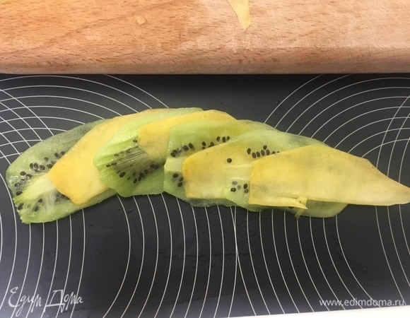 Вообще, конечно, украшать можно абсолютно по-разному, это уже дело вкуса и фантазии! Я решила сделать розочки-украшения. Для этого чередуем тонко нарезанные кусочки киви и манго. Слегка придерживая ножом, закручиваем розу.