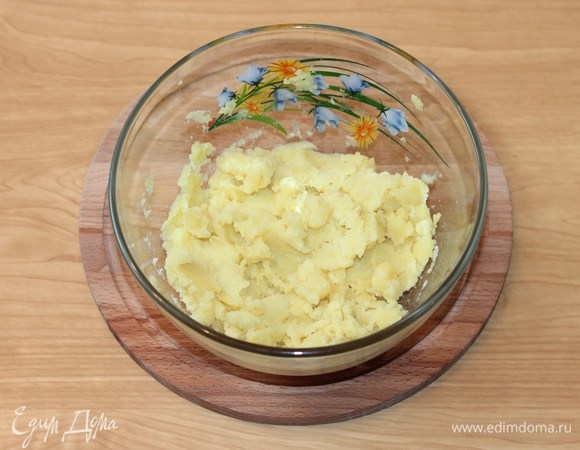 Затем выложить картофель в большую миску и истолочь в пюре.