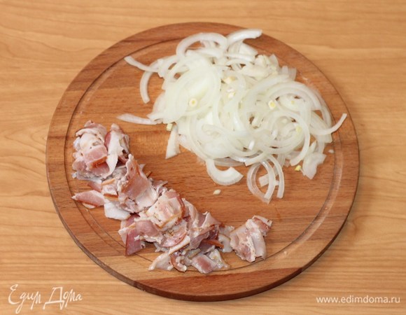 Тонко нарезать репчатый лук полукольцамии, бекон — полосками.