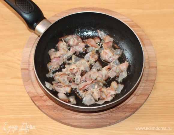 На разогретом растительном масле обжарить бекон.