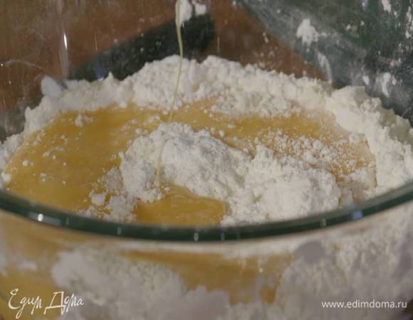 Яйца и желток разболтать вилкой, затем влить граппу, все перемешать и влить в муку.