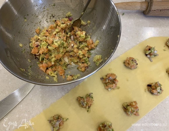 На одну половину теста на некотором расстоянии друг от друга порциями по полчайной ложки выложить рыбную начинку, накрыть второй половиной теста, влажными руками скрепить края и рюмкой вырезать кружки теста с начинкой посредине. Я немного отошла от того, как описано в книге, и сделала так: выложила фарш вокруг пальцем, смоченным в воде, обошла каждую порцию фарша и накрыла сверху вторым тестом, примяв края, затем вырезала рюмкой.