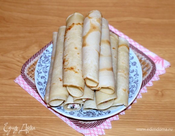 На блин выложить немного начинки и свернуть рулетиком.