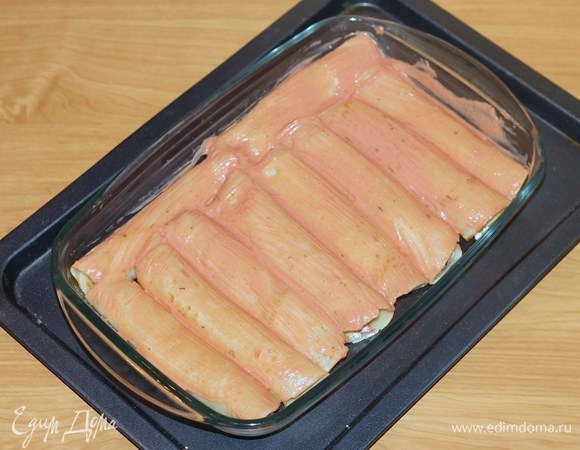 Смазать блины сметанным соусом и отправить в разогретую духовку на 15 минут.