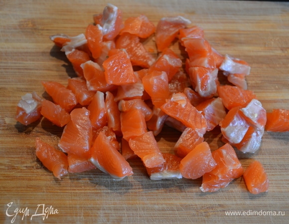 Тем временем нарезать рыбу на небольшие кусочки. Оставить несколько ломтиков для украшения.