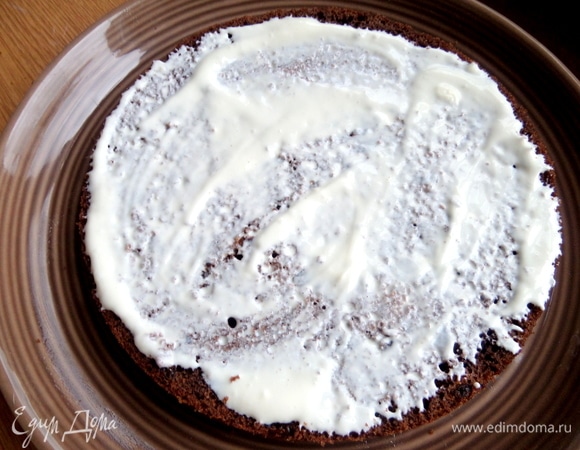 Берем тарелку для подачи, на нее кладем корж-основу. Смазываем кремом.