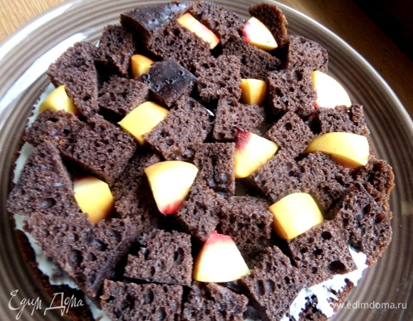 На крем положить слой кубиков, между ними — кусочки персика.