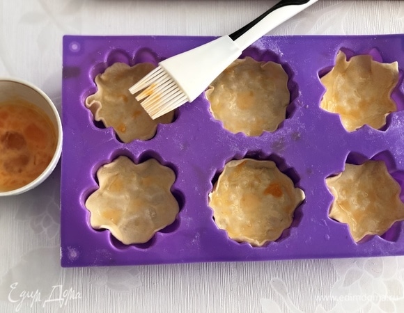 Сформируйте из квадратов корзиночки и смажьте яйцом. Затем выпекайте в духовке 20 минут.