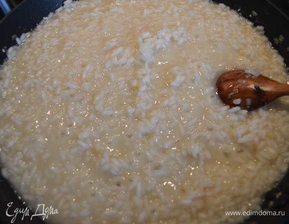 Далее небольшими порциями добавлять бульон, непрерывно помешивая. Всего ризотто готовится 18–20 минут. Минут за 5 до приготовления влить остальное вино, всыпать пармезан и обязательно помешивать.