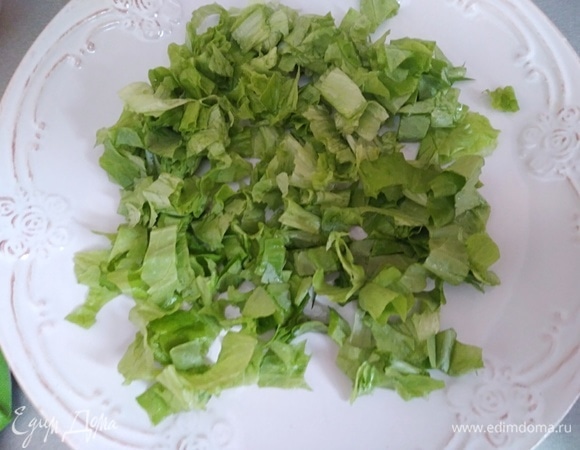 На блюдо выложить лист салата. Предварительно его вымыть, обсушить и нарезать. Сбрызнуть соком лимона.