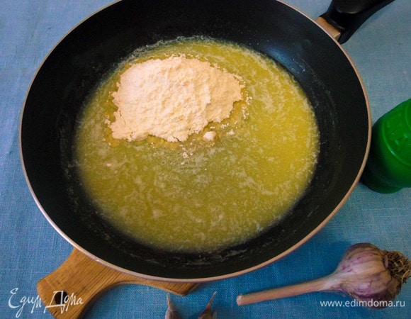 Пока картофель запекается в духовке, приготовим сливочный соус. На среднем огне на сковороде растопить сливочное масло. Непрерывно помешивая, всыпать муку.