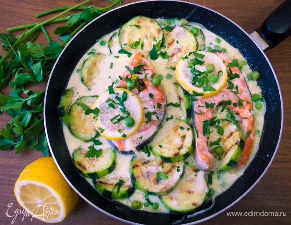 Запеченный лосось выложить в сливочно-овощную смесь, сверху тоже полить рыбу соусом. По желанию украсить дольками лимона и зеленью (у меня нарезанные листья петрушки).