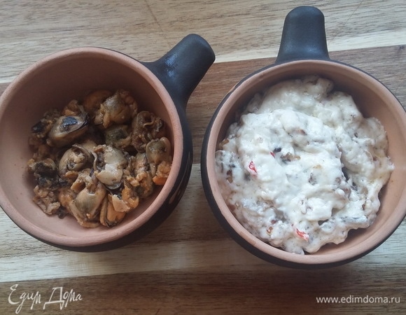 Разложить мясо мидий по кокотницам, сверху добавить получившийся соус и луково-грибную смесь.
