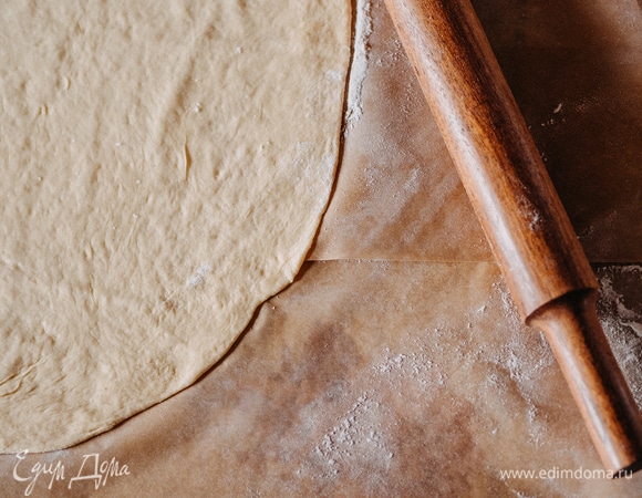 Посыпьте поверхность мукой и тонко раскатайте тесто.