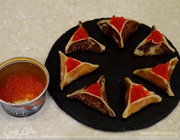 В середину каждого треугольника положите по ложечки икры.