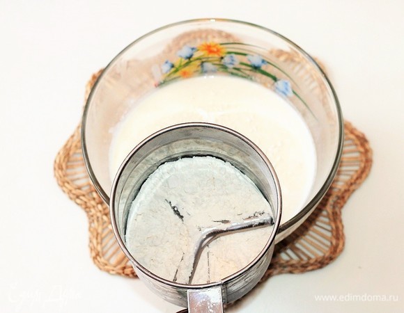 Вмешиваем в молочную смесь небольшими частями (по 1 ст. л.) просеянную муку.