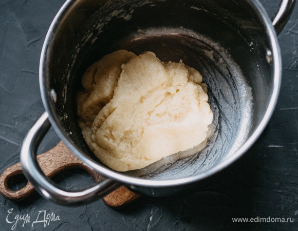 Добавить муку и вернуть кастрюлю на огонь, постоянно помешивая (примерно 2–3 минуты). Тесто соберется в шар, а на дне кастрюли появится белая корочка.