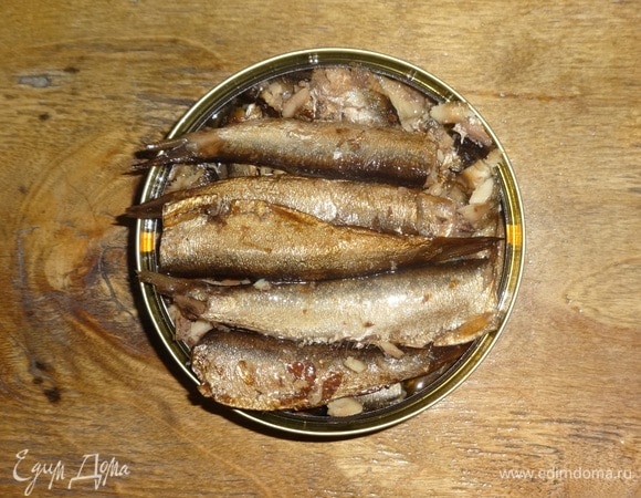 Открыть банку со шпротами. Слить масло из банки в миску.