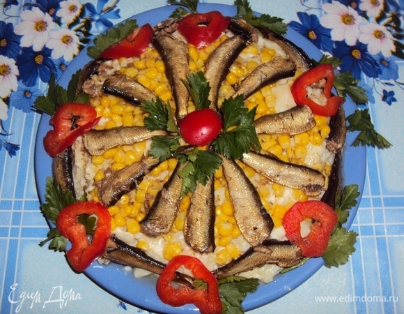 На дно плоской тарелки выложить картофельно-луковую смесь, затем — кукурузу и шпроты (в виде цветка). Оставшиеся шпроты выложить по бокам. Полить салат половиной масла из банки. Украсить кружками красного перца и петрушкой. Подать к столу. Угощайтесь! Приятного аппетита!