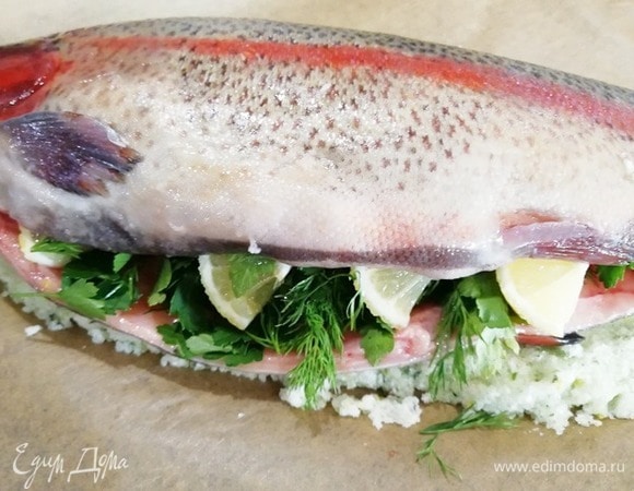 В брюшко форели помещаем листья петрушки, укропа и нарезанный лимон.