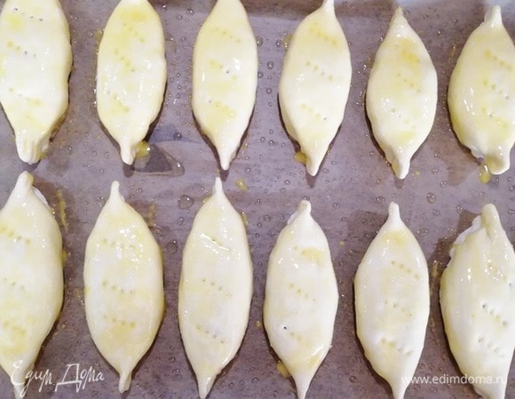 Яйцо взбить вилкой и смазать пирожки со всех сторон.