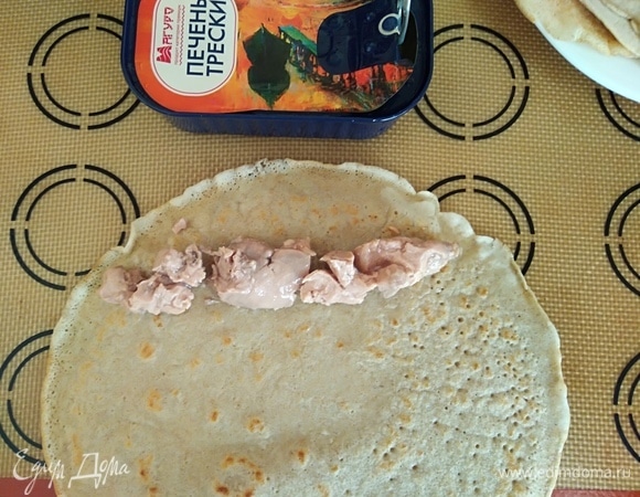 Собираем роллы. На край блинчика положить немного печени трески.