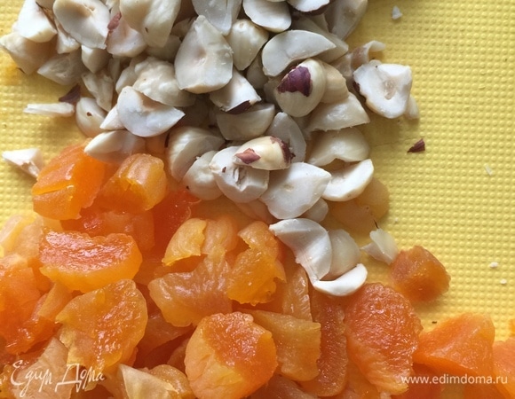 Курагу нарезать, орехи крупно порубить, затем добавить в тесто.