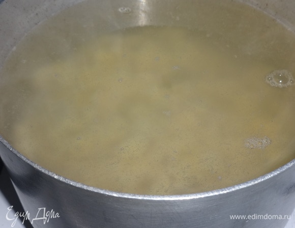 В кастрюлю налить воду, положить картофель и поставить на огонь. Когда закипит, убавить огонь, немного посолить и варить почти до готовности картофеля.