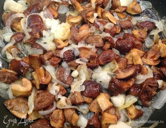 Разогреваю сковородку, наливаю масло, добавляю грибы. Нарезаю лук, кладу к грибам. Добавляю соль, перец, чеснок. Жарю до готовности.