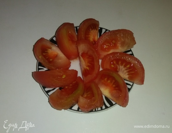 Спустя 20 минут достаем помидор из воды, очищаем от кожицы и режем его крупными дольками.