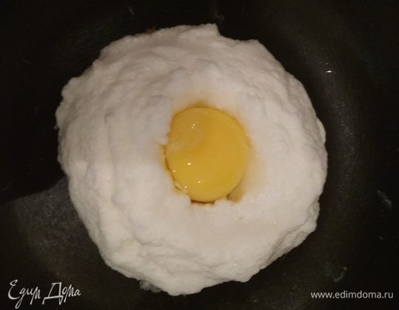 Далее переворачиваем на другую сторону. Выкладываем оставшиеся взбитые белки, делая в центре ямку (углубление). В ямку кладем желток, солим и накрываем крышкой. Держим на небольшом огне также до подрумянивания второй стороны рыбной основы, за это время белки увеличатся немного в размере и вместе с желтком приготовятся и прогреются.