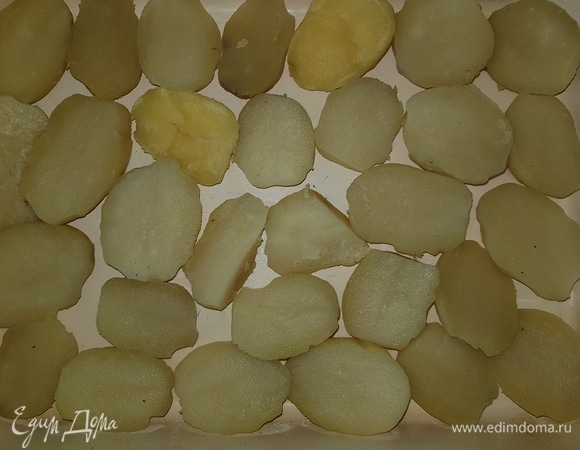 Картофель помыть и отварить в подсоленной воде. Форму для запекания смазать подсолнечным маслом. Картофель почистить и разрезать пополам. Выложить в форму срезом вверх.