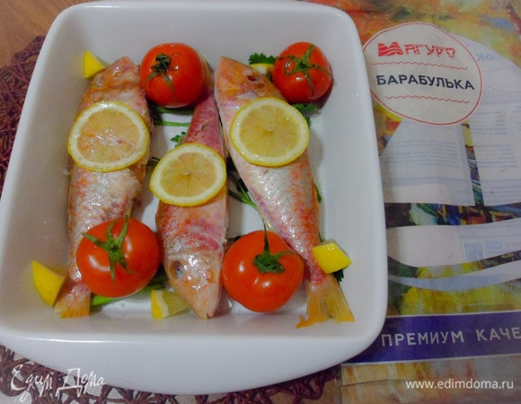 На каждую тушку положить по дольке лимона, оставшийся лимон нарезать мелкими кусочками и тоже положить в форму. Добавить несколько некрупных томатов. Отправить в разогретую до 180°C духовку на 20 минут.