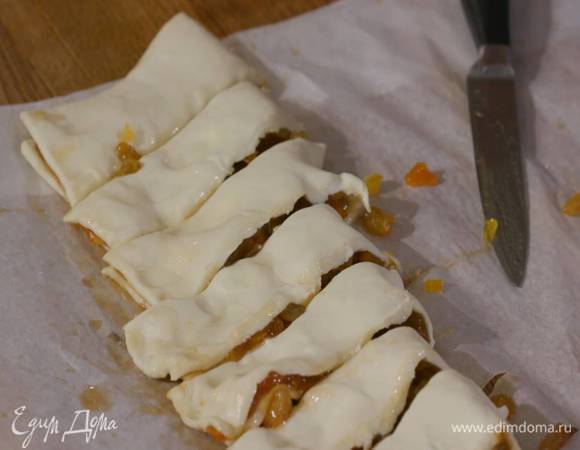 Сложить тесто с начинкой пополам по длинному краю и нарезать полосками шириной 2‒3 см.