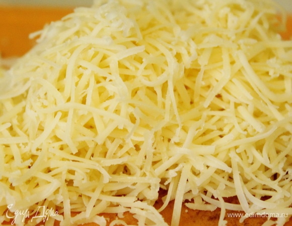 Сварить поленту в подсоленной воде до готовности. Добавить в нее половину натертого сыра. Выложить в форму для запекания и оставить охлаждаться.