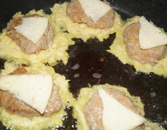 В сковороду добавьте растительное масло и начинайте выкладывать ваши цеппелины: вначале столовую ложку картофельной массы, затем — кусочек сыра, на него — половину котлеты срезом вниз, вновь кусочек сыра, закрываем все это картофельной массой, выравнивая ее по краям.