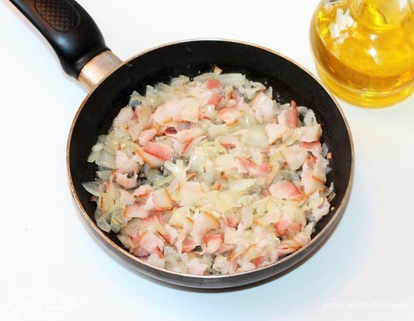 Разогреть в сковороде 2 ст. л. оливкового масла и, помешивая, обжарить лук и бекон до золотистого цвета.