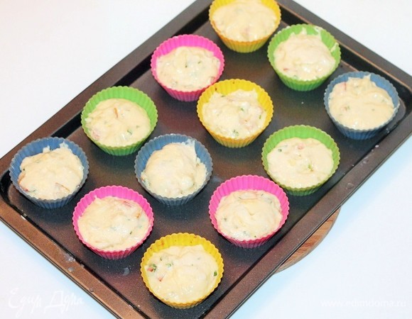 Разложить тесто в силиконовые формочки для кексов, заполняя их на 2/3 объема.