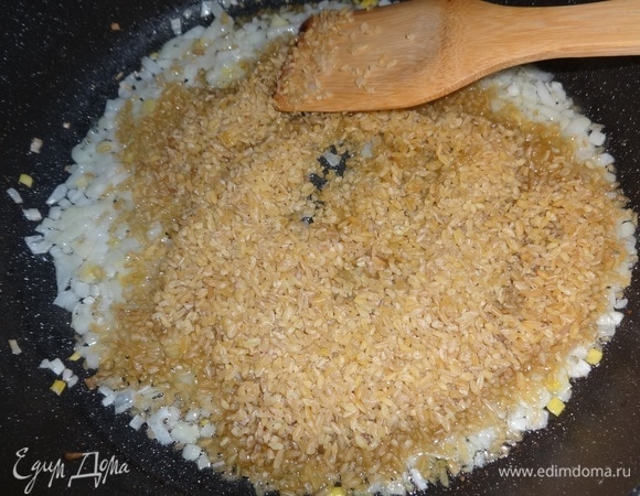 Всыпать в сковороду булгур и обжарить вместе с луком, помешивая, в течение нескольких минут.
