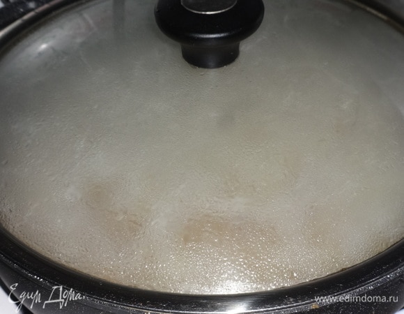 Накрыть сковороду крышкой и потушить крупу с луком 5–7 минут.