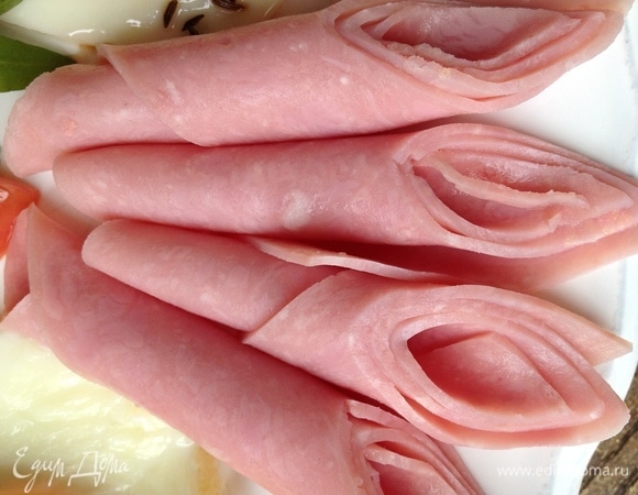 Кусочки ветчины скатать в рулетик, разрезать пополам.