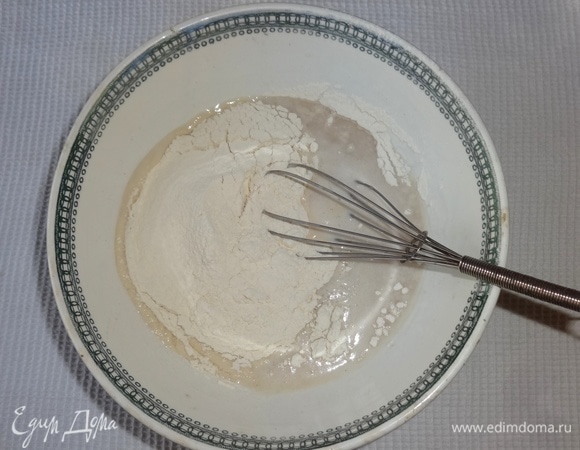 Порциями добавлять просеянную муку и перемешивать.